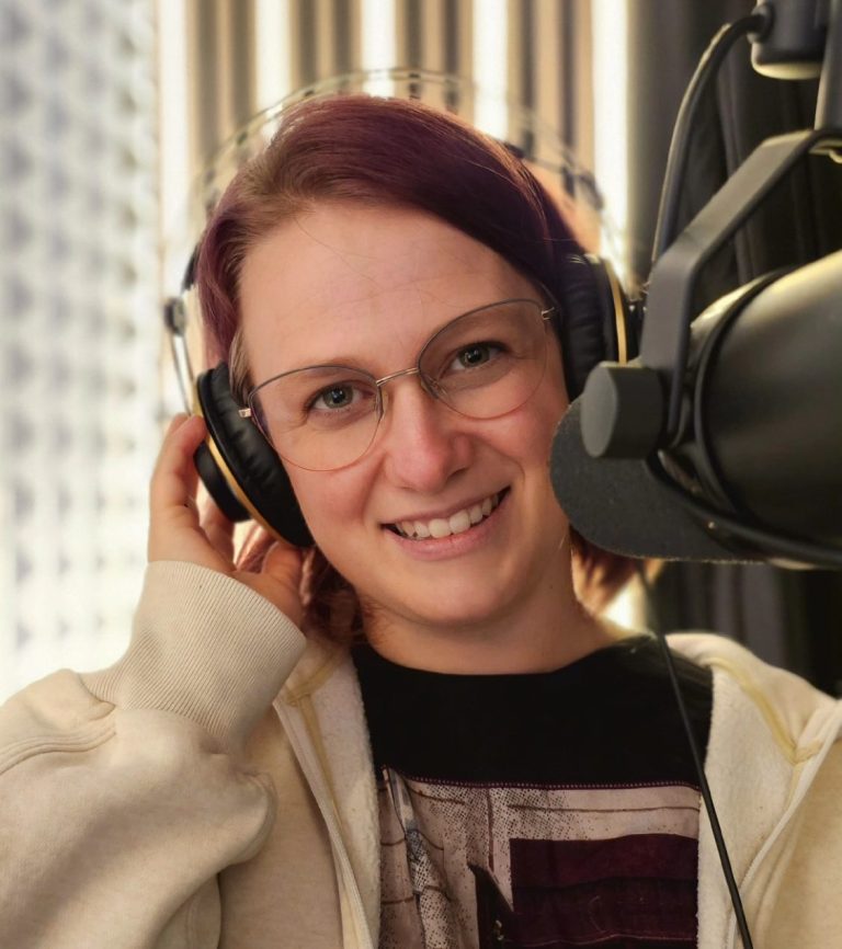 Sandra Hümmelgen steht mit Kopfhörern vor einem Mikrofon steht.